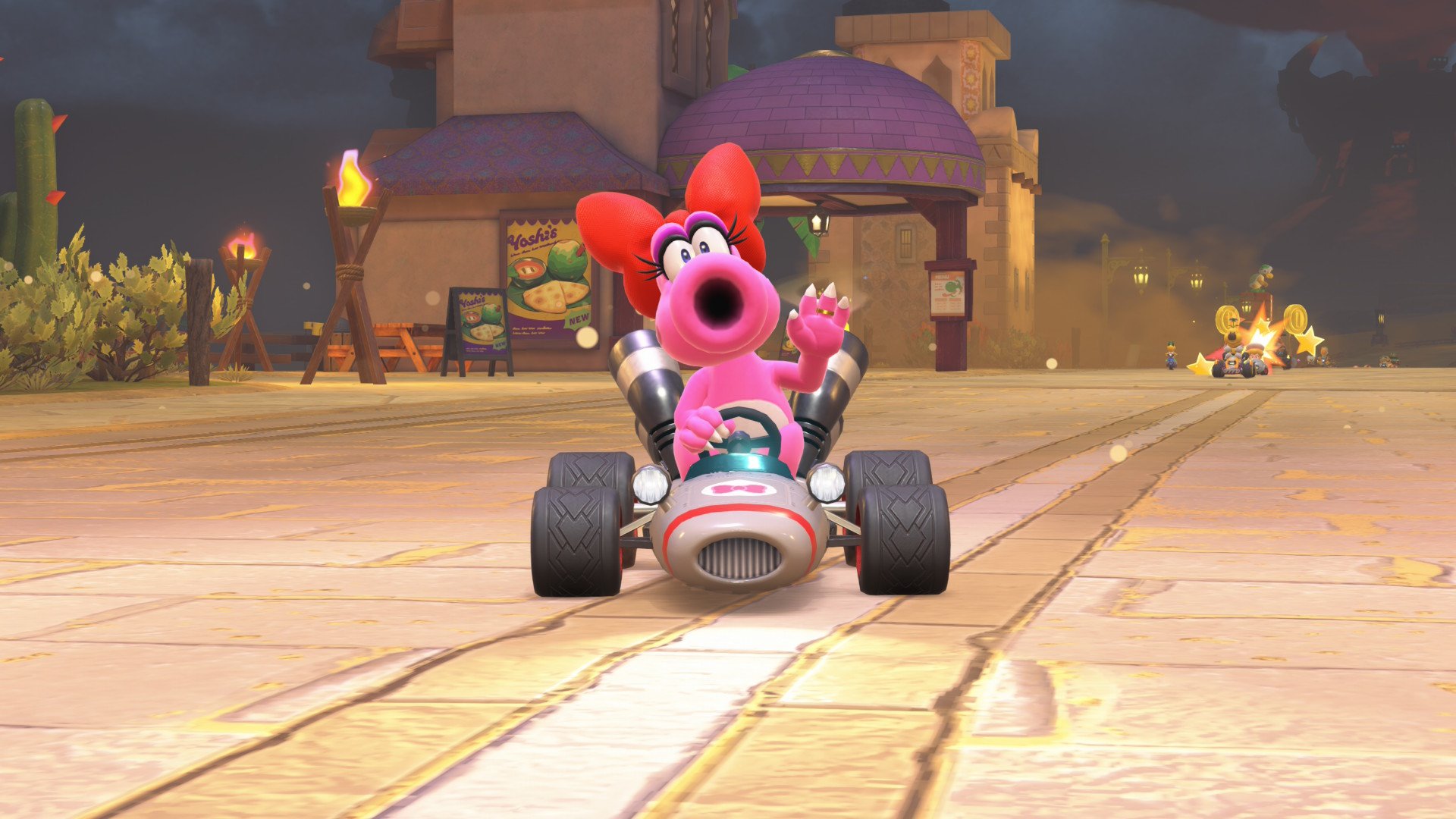Birdo waves while driving a kart.