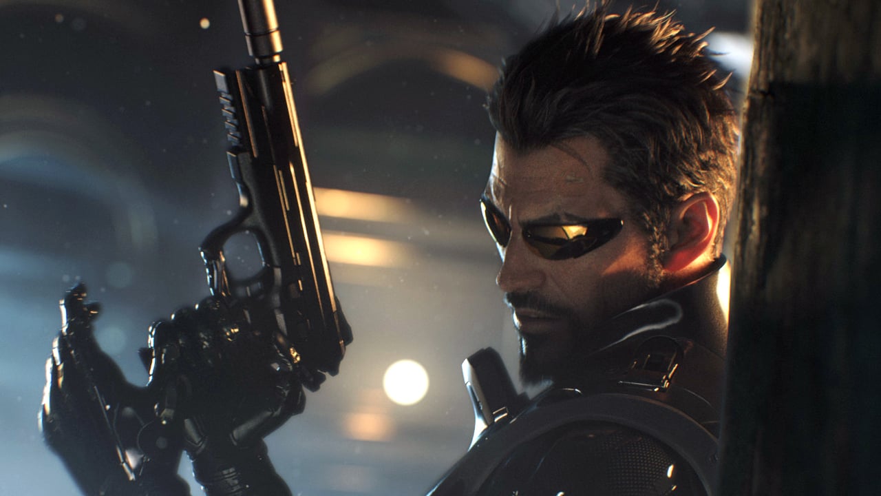 Adam Jensen reloads a silenced pistol from behind cover.